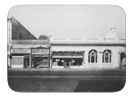 View of corner of North First and West B street circa 1946 Purity store, Dixon meat market, Beauty parlor, Gem pharmacy, and G.E.M. saloon, gardners appliance store and first national bank.